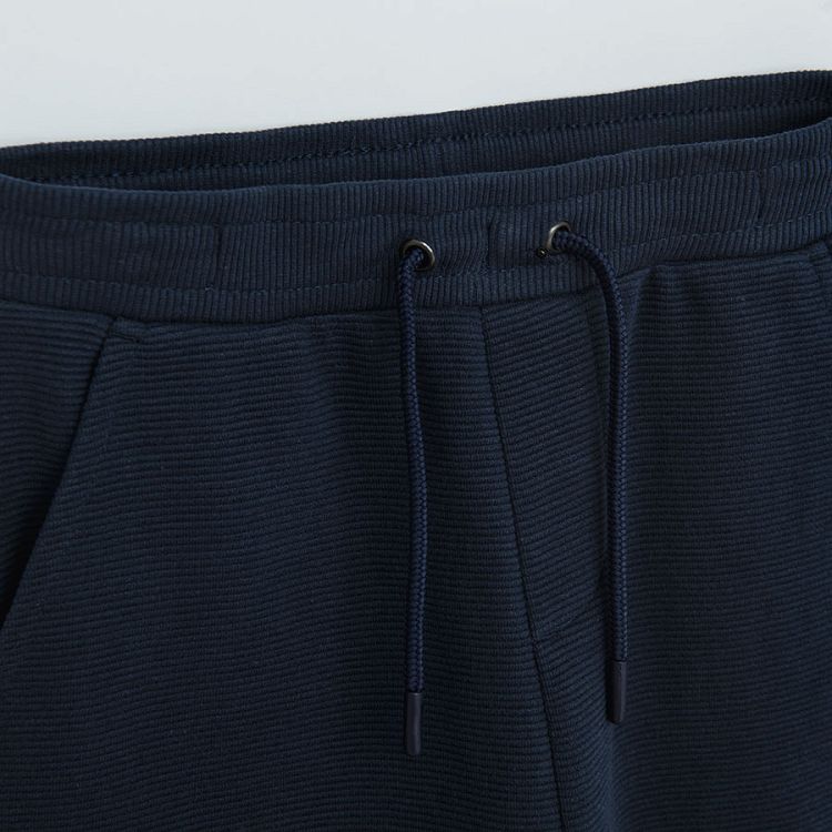 Dark blue jogging pants with cord and elastic around the ankles