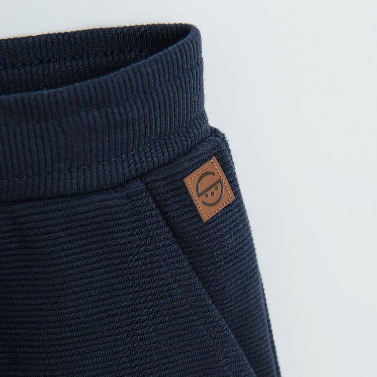 Dark blue jogging pants with cord and elastic around the ankles