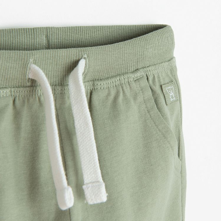 Green jogging pants with lions head on the knees