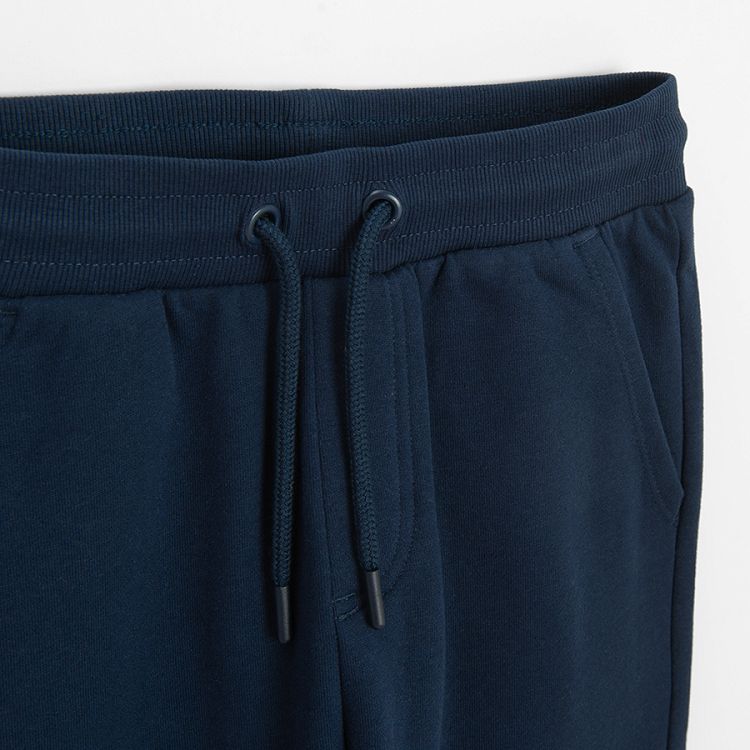 Dark blue sweatpants with elastic around ankles and cord