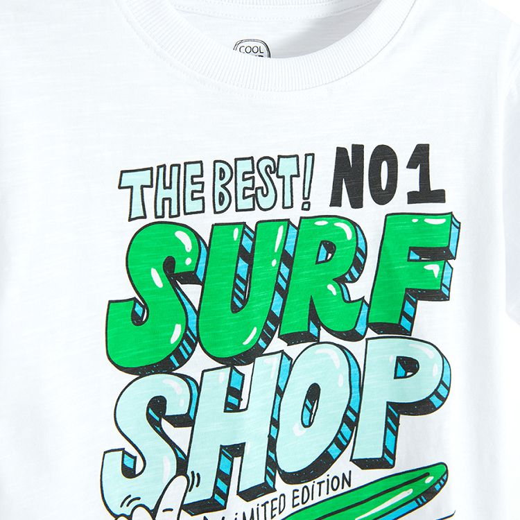 חולצת טריקו לבנה עם הדפס 'THE BEST #1 SURF SHOP'