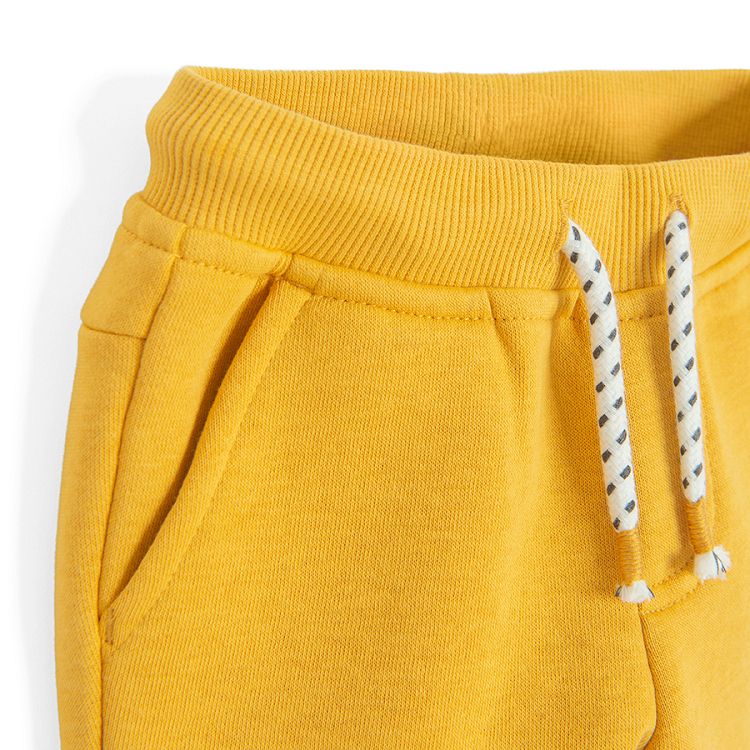 Yellow jogging pants with corded waist and elastic around the ankles