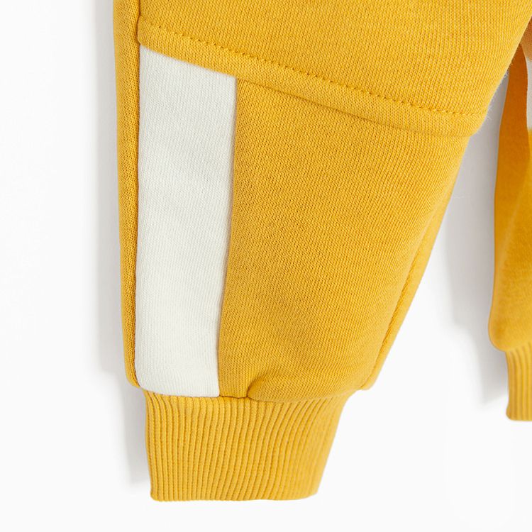 Yellow jogging pants with corded waist and elastic around the ankles