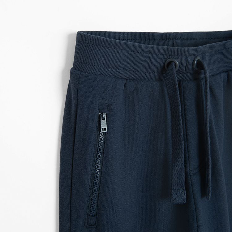 Blue jogging pants with corded waist and elastic around the ankles