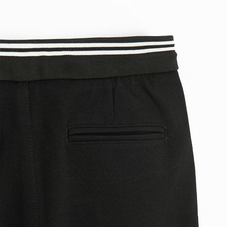 Black pants with white stripes on the belt and cord