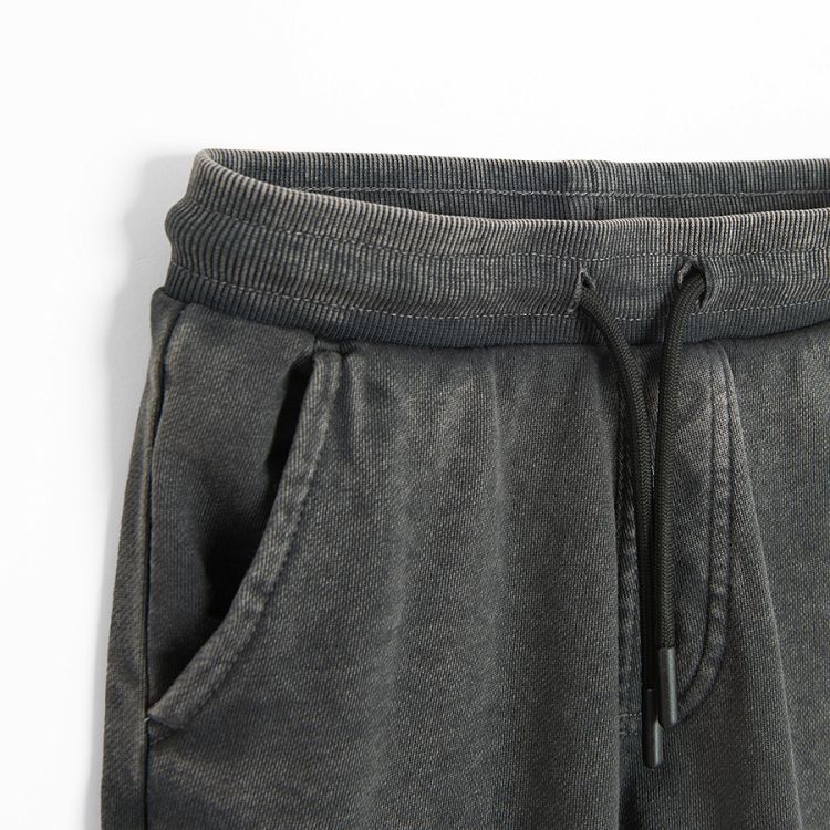 Grey jogging pants with corded waist and elastic around the ankles