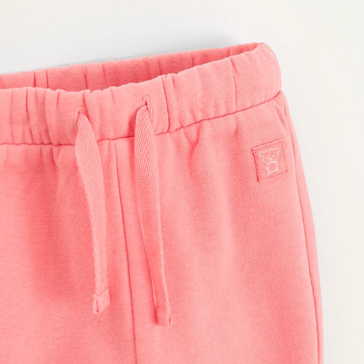 Pink sweatpants with elastic around the ankles and cord on the waist