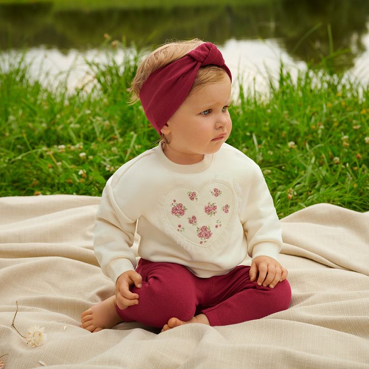 White sweatshirt with a heart print andburgundy leggings and headband