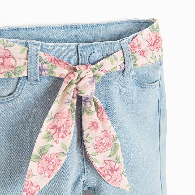 Light blue denim trousers with floral belt