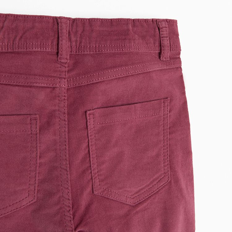 Burgundy trousers with flowers embroidered around the pockets