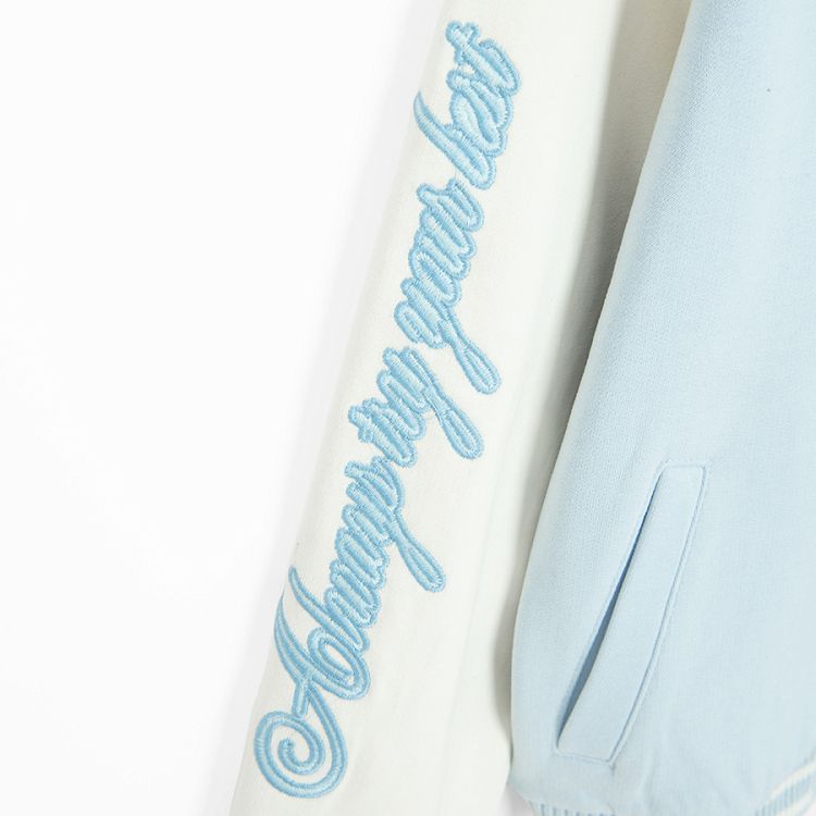 White and light blue buttons sweatshirt with D and Dreams print on the back