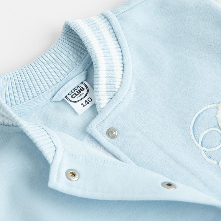 White and light blue buttons sweatshirt with D and Dreams print on the back