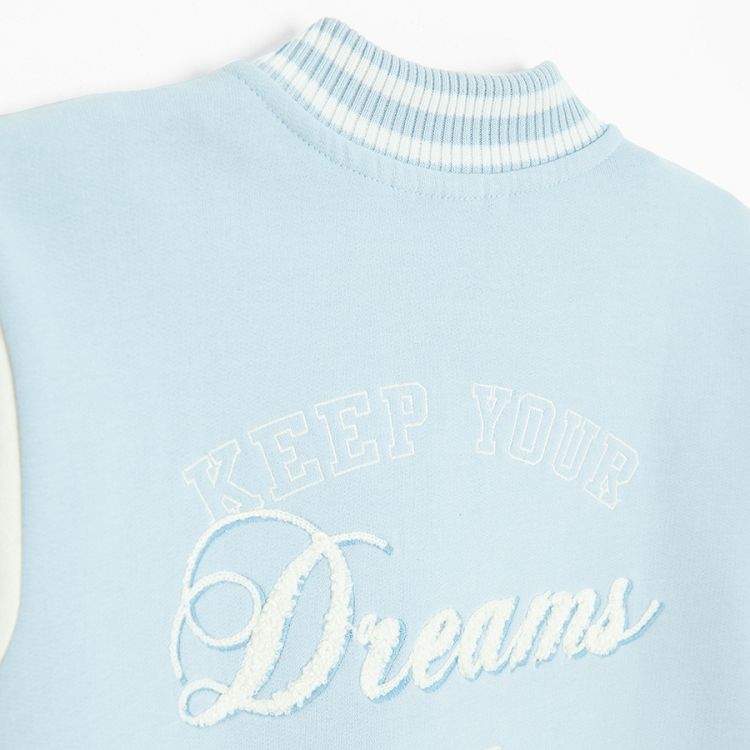 White and light blue buttons sweatshirt with D and Dreams print on the back