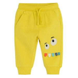 Yellow jogging pants with funny face on knee