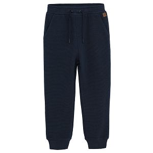 Dark blue jogging pants with cord and elastic around the ankles