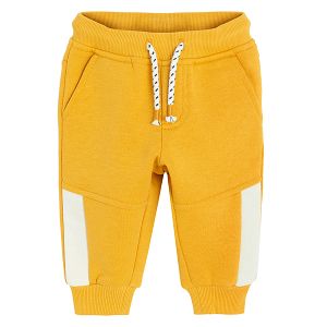 Yellow jogging pants with corded waist and elastic around the ankles