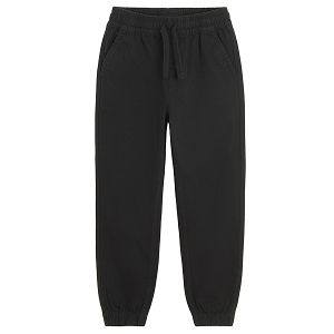 Black trousers with corded waist and elastic around the ankles